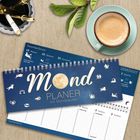 Mondplaner 2026/2027, Spiralbindung, neben einer Tasse Kaffee, Schreibutensilien und Blättern auf Holzoberfläche.