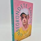 „UNBEGRÜNDETE ÄNGSTE“, Res Sigusch. Buchcover: Junge im gelben Shirt und weißer Kappe auf rosa Hintergrund.