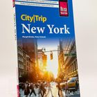 „CityTrip New York“ von Margit Brinke und Peter Kränzle. Foto von einer geschäftigen Straße bei Sonnenuntergang in New York.