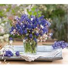 02 mit Kalendertagen daneben, ein Bukett aus blauen und weißen Blumen in einem Glas auf einem Tablett.