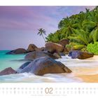 Strand auf der Insel Silhouette, Seychellen. Februar-Kalenderblatt mit Palmen, Felsen und sanften Wellen am Ufer.
