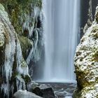 02, 01-15, Eiszapfen in Schlucht, Wasserfall, moosbedeckte Felsen, winterliche Szene.