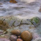 Kalender für Februar mit Küstenlandschaft: Steine am Strand, ruhiges Meer, bewölkter Himmel.
