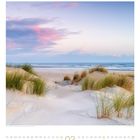 Februar-Kalender mit Dünen am Strand bei Sonnenuntergang. Gräser und ruhiges Meer im Hintergrund.