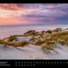 02: Dünenlandschaft auf der Nordseeinsel Amrum. Sanddünen mit Gras unter einem bunten, wolkigen Himmel beim Sonnenuntergang.