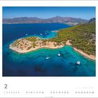 Kalenderbild für Februar. Eine Küstenlandschaft mit klarem, blauem Wasser, Booten und grünen Hügeln im Hintergrund.