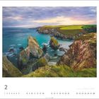 "National Coast, Wild Atlantic Way, County Cork." Rugged Klippen münden in türkisfarbenes Meer, unter bewölktem Himmel.