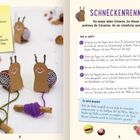 **Schneckenrennen**  
Material: Pappe, Kastanien, Acrylstifte, Bastelkleber, bunte Wolle, Äste, Schere.  
Zwei gebastelte Schnecken mit bunten Wollfäden.