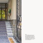 01 EINFÜHRUNG 13. Bild zeigt einen eleganten Hauseingang mit Marmortreppen, Pflanzen und eisernen Geländern.