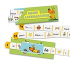 „MEINE LESEMASCHINE“ in gelber Schrift auf grünem Hintergrund. Darunter Bilder mit Wörtern wie „Tasche“ und „Stuhl“.