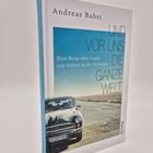 "Andreas Babst. Und vor uns die ganze Welt. Eine Reise über Land von Indien in die Schweiz." Auto auf einsamer Straße.