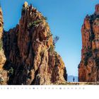 Februar, Tage nummeriert. Zwei imposante Felsen und eine Person auf einem Weg darunter, klarer blauer Himmel.