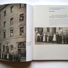 Texte: "die Eisenbahnbediensteten-Colonie", "Brot und Milch", "um 1910".  
Links: Schwarzweißfoto eines Gebäudes mit Menschen. Rechts: Textseite.