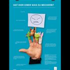"HAT HIER EINER WAS ZU MECKERN?" steht oben. Eine Hand mit Fingerpuppen hält ein Schild mit einem wütenden Gesicht.