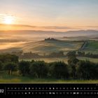 Ein Kalenderblatt zeigt eine toskanische Landschaft. Morgenstimmung im Val d’Orcia mit sanften Hügeln und Sonnenaufgang.