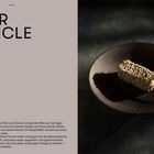 "Kaviar Popsicle: Holzstiel mit 'CODA' graviert, Kaviar umhüllt Eis auf einem Teller in dunkler, stimmungsvoller Beleuchtung."