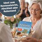 „Ideal zum Renteneintritt, Abschied oder Ruhestand.“ Frau hält ein Geschenk mit Buch „Endlich Ruhestand. Man lernt nie aus“.