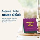 Neues Jahr neues Glück. Kalender auf Holzunterlage, lila Cover. Text: WENIGER IST MEHR*.