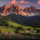 St. Magdalena, Villnößtal (Italien) 2. Kalender mit Berglandschaft, grünen Hügeln, Häusern und einer Kirche in der Abenddämmerung.