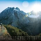 Unten ein Monatskalender von 1 bis 28, darüber Berge, Sonne und ein Mountainbiker auf einem Pfad.