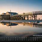 Seebrücke Sankt Peter-Ording, Kalender mit Datumszahlen. Hölzerne Seebrücke und Gebäude spiegeln sich im Wasser bei Sonnenuntergang.