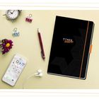 "Timer 2026/27" auf einem schwarzen Notizbuch mit geometrischem Muster, daneben Uhr, Blumen, Stift, Smartphone, Kopfhörer.