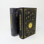 Zwei Bücher mit dem Titel "ALCHEMISED". Das rechte Buch hat ein okkultes Muster in Gold auf schwarzem Einband.