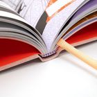Ein aufgeschlagenes Buch mit farbigen Seiten und einem orangefarbenen Leseband.