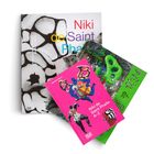 Bücherstapel: "Niki de Saint Phalle", "The Grotto", "Niki de Saint Phalle A-Z". Cover mit bunten, abstrakten Kunstwerken.