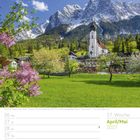 April/Mai 2027, 17. Woche. Kirche vor schneebedeckten Bergen, blühende Bäume im Vordergrund.