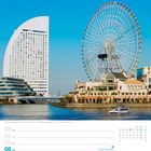 Kalender der 18. Woche im Mai. Ansicht eines großen Riesenrads und eines markanten halbrunden Gebäudes an einem Flussufer.