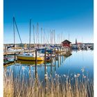 21. Mai. Mo 24, Di 25, Mi 26, Do 27, Fr 28, Sa 29, So 30. Boote im ruhigen Hafen, blauer Himmel und Gräser am Ufer.