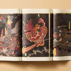 Japanische Schriftzeichen neben Samurai und einem Dämonen auf einer traditionellen japanischen Illustration.
