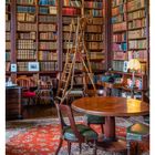 "24 Juni. Mo 14 Di 15 Mi 16 Do 17 Fr 18 Sa 19 So 20. Bibliothek mit Holztisch, Bücherregalen, Leiter, roten Teppich, antiken Möbeln."