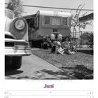 Text: "Familie in einer Wohnwagen-Siedlung bei Phoenix · USA · 1958", "Juni", "KW23/2027".  
Ein altes Auto, Wohnwagen, Familie im Freien.