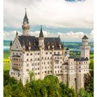 27 JULI. Mo 05 Di 06 Mi 07 Do 08 Fr 09 Sa 10 So 11. Schloss Neuschwanstein steht auf grünem Hügel unter blauem Himmel.