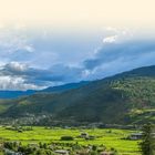 Der Text "REISEREPORTAGEN" steht über einer idyllischen Landschaft mit grünen Feldern, Hügeln und vereinzelten Häusern.