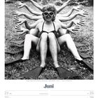 Juni; Junge Frauen am Strand von Hamburg - Deutschland - 1954. Frau mit Taucherbrille und acht Armen, auf Rasen sitzend.