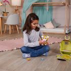 Ein Kind sitzt auf einem Holzboden in einem gemütlichen Raum und spielt mit einem Plüschtiger.