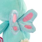 Ein türkisfarbenes Plüschtier mit blauen Flügeln und rosa Punkten.
