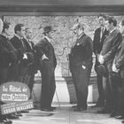 Text: "Das Rätsel der roten Orchidee" und "EDGAR WALLACE". Zwei Gruppen von Männern in Anzügen stehen vor einer großen Karte.