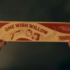 "ONE WISH WILLOW", "AMAZE YOUR FRIENDS!", "You only get ONE WISH". Hände halten eine Packung mit roten Zeichnungen.