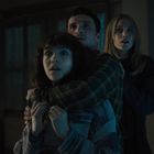 Keine Texte sichtbar. Drei Personen wirken erschrocken in einem dunklen Raum. Licht fällt von links ein.