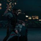 Zwei Männer kämpfen auf einem dunklen Dach in einer Stadt, umgeben von Graffiti und erleuchteten Fenstern.