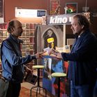 Zwei Männer in einem Laden, Text auf einem Schild: "Wenn Sie mich fragen", "Tipp", "kino". Viele DVD-Hüllen im Hintergrund.