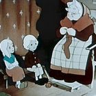 Eine Illustration zeigt eine ältere Frau beim Stricken mit zwei sitzenden Kindern, die ihr zusehen.