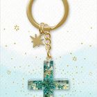 „Dein Wegbegleiter“ steht oben, „COPPENRATH“ unten. Schlüsselanhänger mit goldenem Ring und grünem Kreuz.