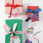 Geschenkboxen mit roten und blauen Schleifen, Lesezeichen in Form von Torten und Herzen, ein Tag mit "Für Teresa".