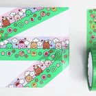 Bunte Klebebänder mit Tier- und Blümchenmustern, Schere daneben, auf Geschenkbox geklebt.