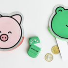 Text: "Rico Design", "Dunico". Zwei Münztaschen in Form eines Schweins und Frosches, Bleistift, Radiergummi, Münzen.